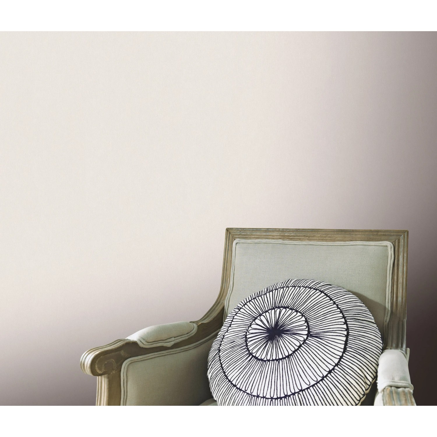 Erismann Vliestapete Versailles Celeste helltaupe an Wand über Sessel mit Kissen.