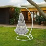 Weißer Vente-unique Orosi Hängesessel aus Polyrattan mit grauen Kissen auf grünem Rasen im Garten.