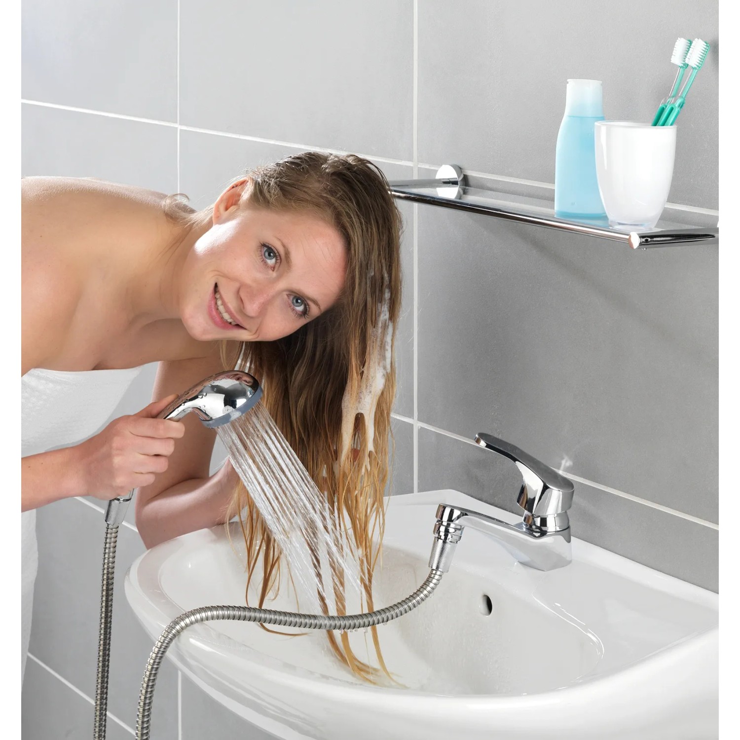 Frau benutzt Wenko Waschbeckendusche Chrom zum Haarewaschen am Waschbecken.