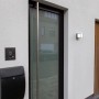 Moderne, anthrazitfarbene LED-Außenwandleuchte Doblo klein an weißer Hauswand.