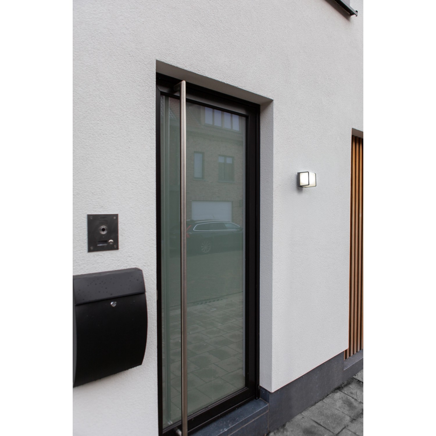 Moderne, anthrazitfarbene LED-Außenwandleuchte Doblo klein an weißer Hauswand.