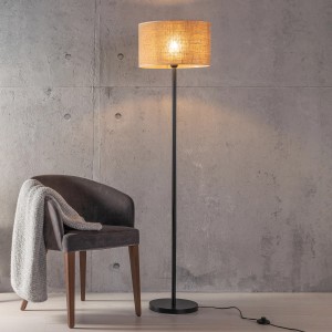 Schwarze Brilliant Stehleuchte Aniela mit Natur-Textilschirm, 1-flammig, neben Sessel.