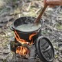 Petromax Hobo-Kocher bk1 aus Edelstahl im Einsatz mit Topf und Kochlöffel. Grillutensil für Outdoor-Küche.