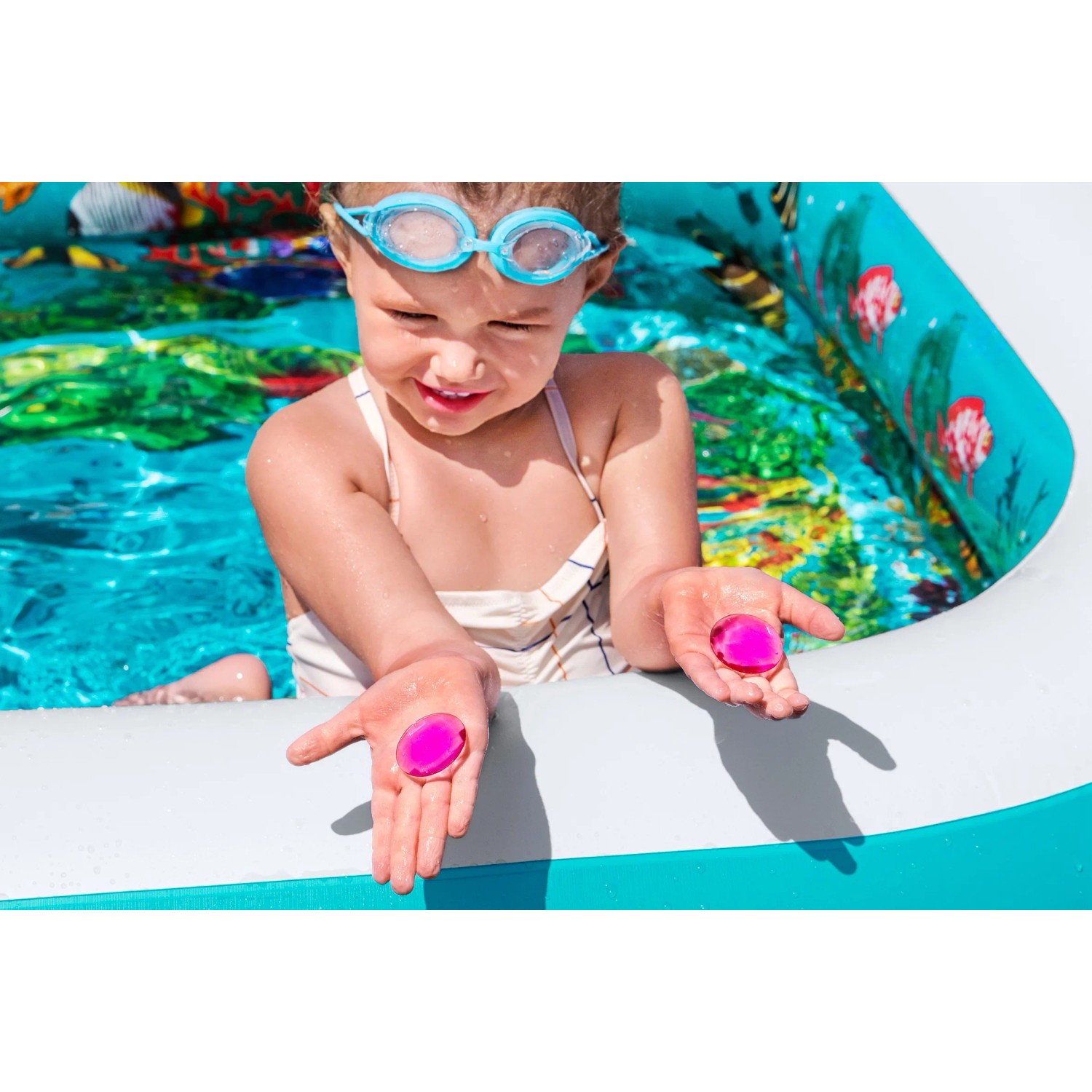 Kind im Bestway Family Pool 3D Undersea Adventure mit 3D-Brille und Spielkristallen.