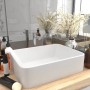 Mattweißes, rechteckiges Keramik-Waschbecken als Einzelwaschtisch auf Holzplatte. Modernes Aufsatzwaschbecken.