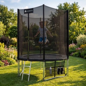 Juskys Gartentrampolin JumpMaster S (schwarz/anthrazit) mit Kind beim Springen im Garten.
