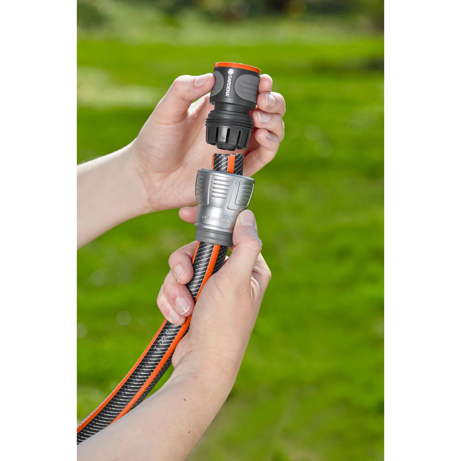 Gardena Premium Schlauchverbinder 3/4 Zoll wird an einem Gartenschlauch befestigt.