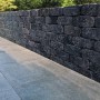 Mauer aus dunklen Diephaus Collo Basalt Mauersteinen (30x20x10 cm).