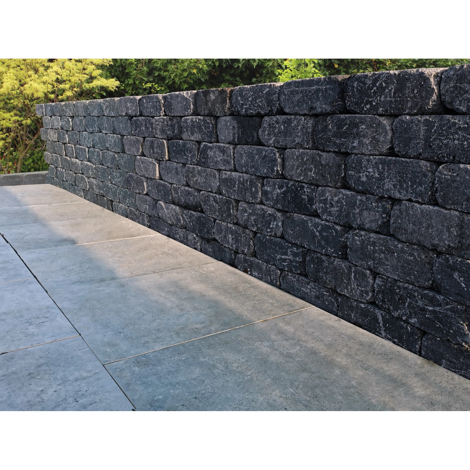 Mauer aus dunklen Diephaus Collo Basalt Mauersteinen (30x20x10 cm).