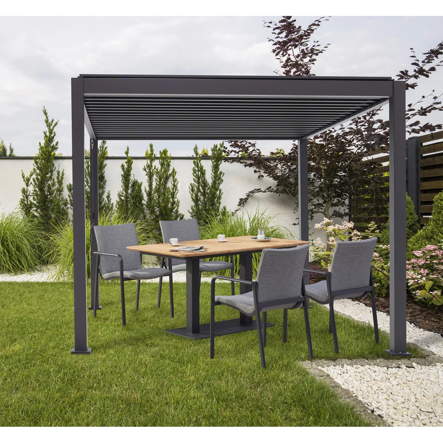 Best Terrassenüberdachung Cadiz 300x400 cm mit Lamellendach und Sitzgruppe im Garten.
