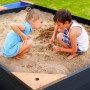 Axi Kelly Sandkasten mit Kindern beim Spielen im Sand, mit Becken und Sitzbank, anthrazit-braun.