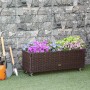 Braunes Outsunny Rattan Hochbeet mit Blumen und Rädern vor Steinwand.