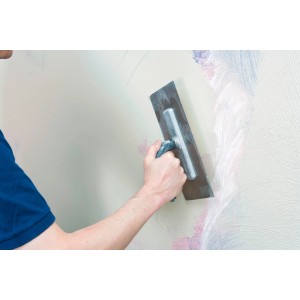 Auftragen von Knauf Rotband Flächenspachtel auf eine Wand mit einer Glättkelle.