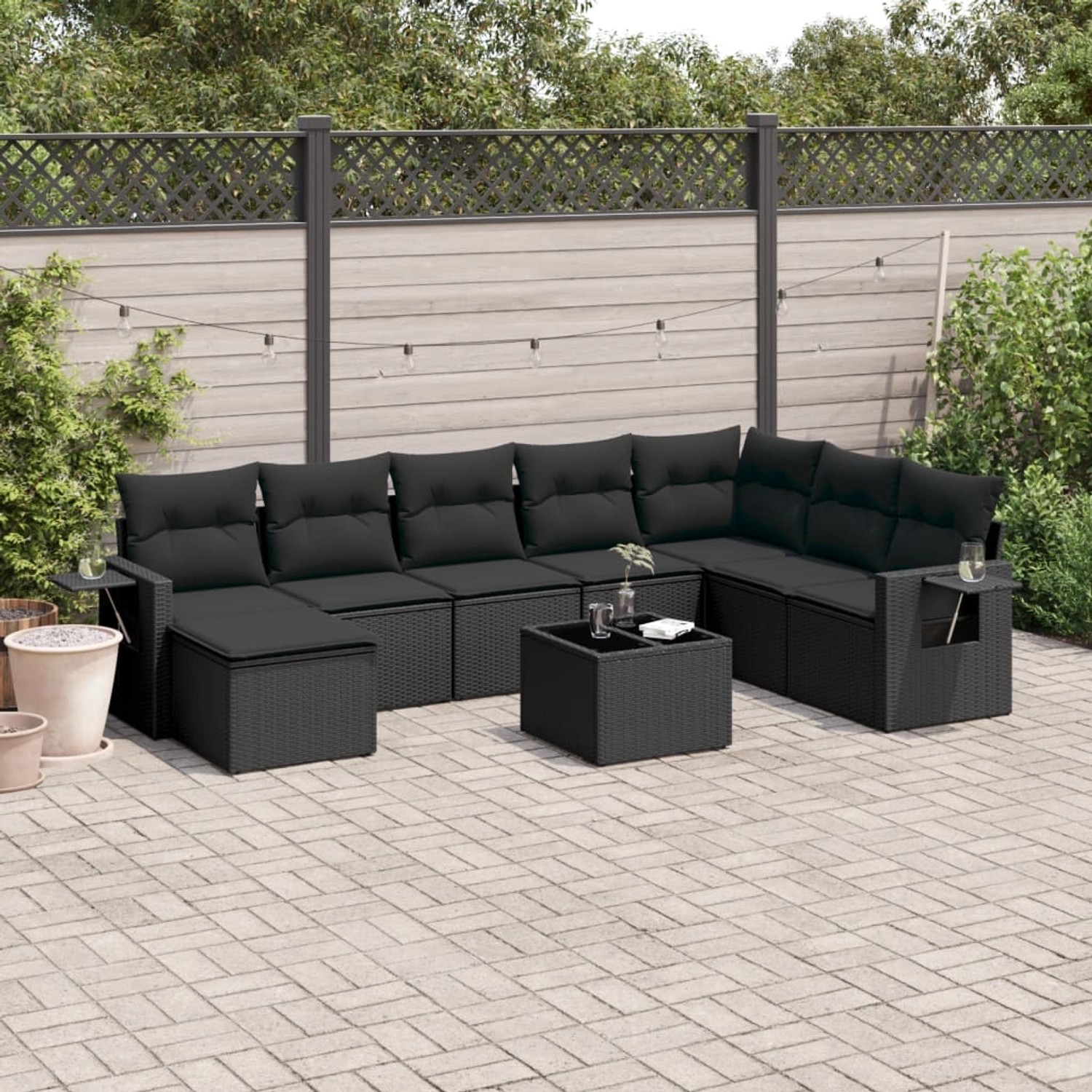 Schwarze 9-teilige Garten Sofagarnitur aus Polyrattan mit Kissen.