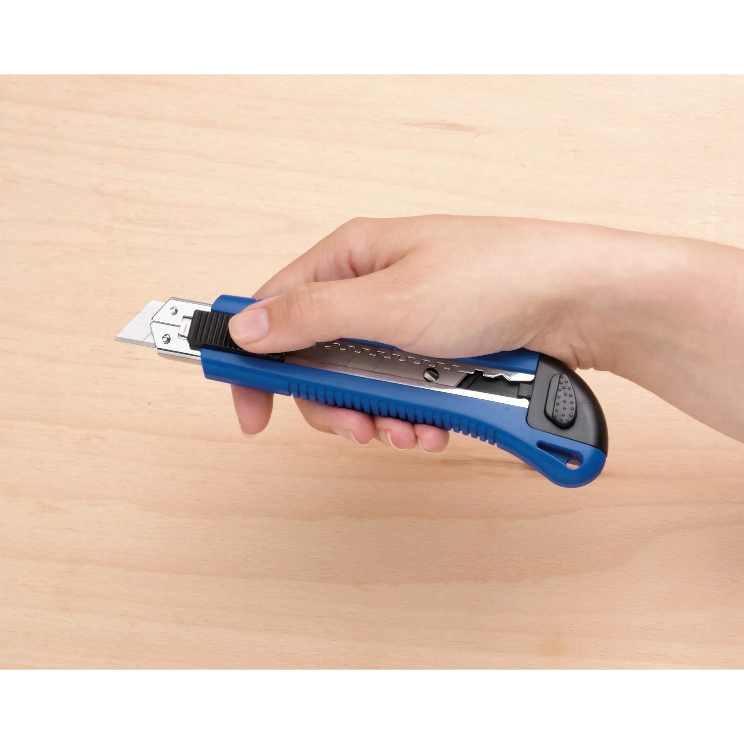 Hand hält blaues LUX Cuttermesser Classic 100 mm. Messer mit Metallgehäuse und Klingenarretierung.