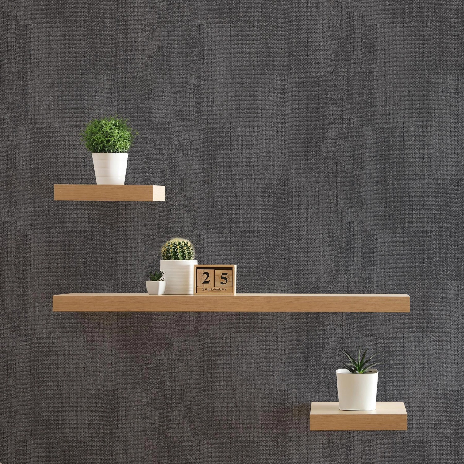 Anthrazitfarbene Tadessi Unitapete mit drei Regalen und Dekoration.