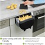 Wenko Tür-Abfalleimer Fago 5L Schwarz für die Outdoor Küche, hängend an einer Schranktür mit Kartoffelschalen.