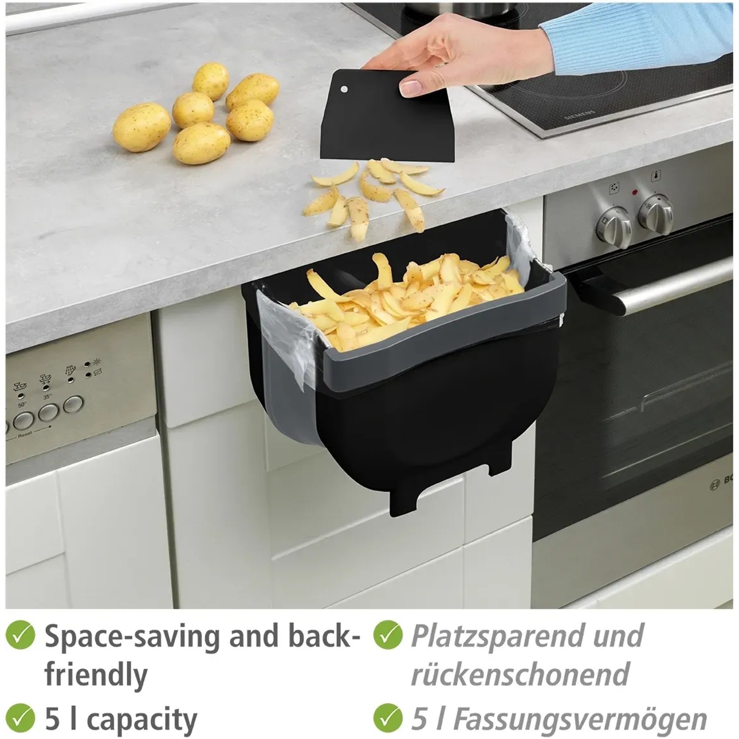 Wenko Tür-Abfalleimer Fago 5L Schwarz für die Outdoor Küche, hängend an einer Schranktür mit Kartoffelschalen.