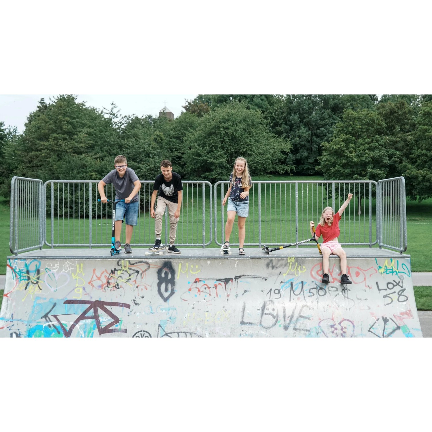 Kinder auf Skatepark mit blauem Six Degrees Stuntscooter. Sport & Fitness.