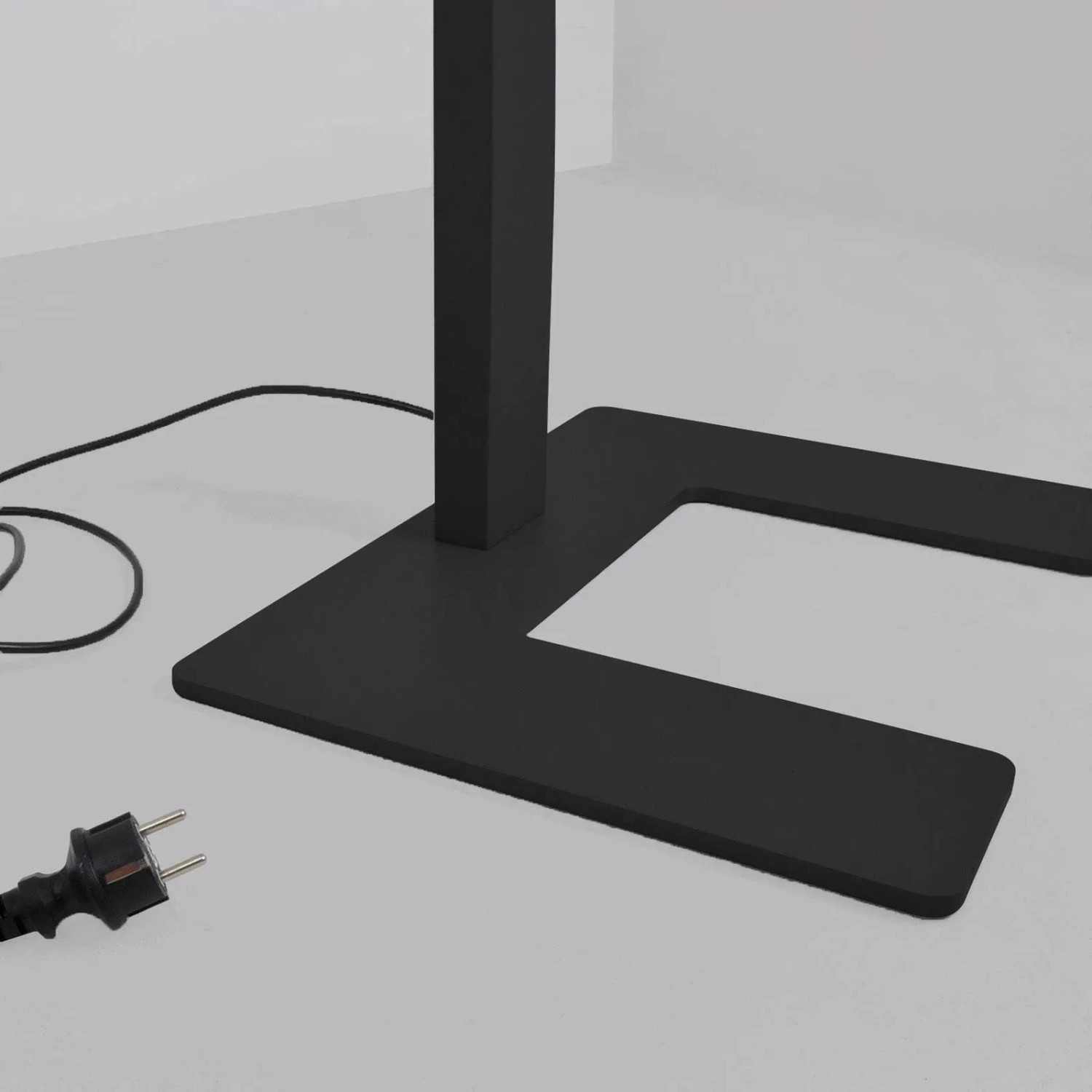 Detailaufnahme der schwarzen Arcchio LED Aila Stehlampe mit Bewegungsmelder, Fokus auf Fuß und Kabel.