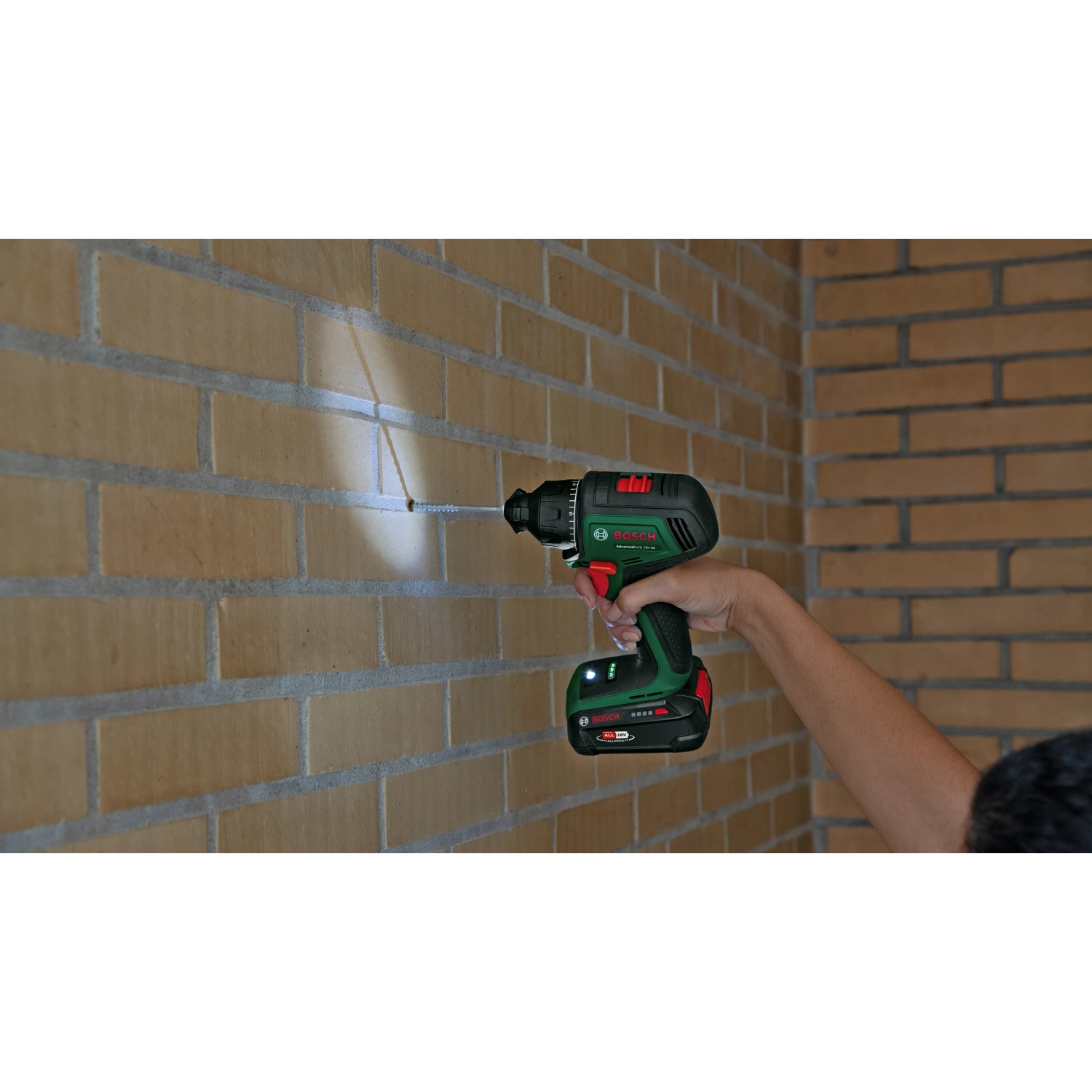 Bosch Advanced Drill 18V-80 Akku-Bohrschrauber beim Schrauben in eine Ziegelwand.