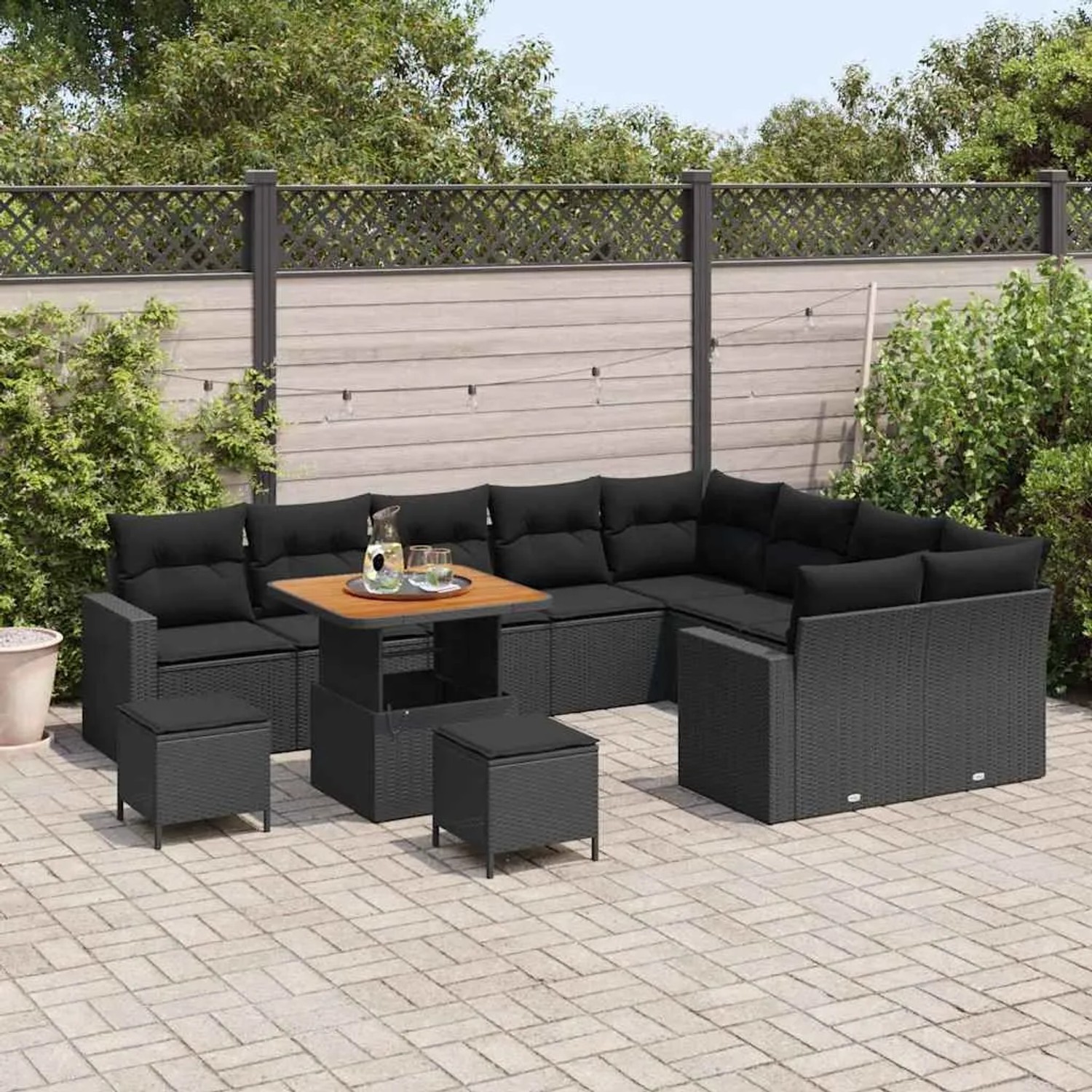 Schwarzes 12-tlg. Garten-Sofa-Set aus Poly Rattan mit Tisch und Hockern für Terrasse und Garten.