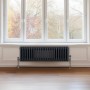 Anthrazitgrauer 3-Säulen Heizkörper (300x1012mm) vor Fenster. Traditioneller Stil für wohlige Wärme.