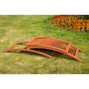 Zusammengeklappte Gartenliege Cuba aus Eukalyptusholz mit Lattenrost auf Rasen.