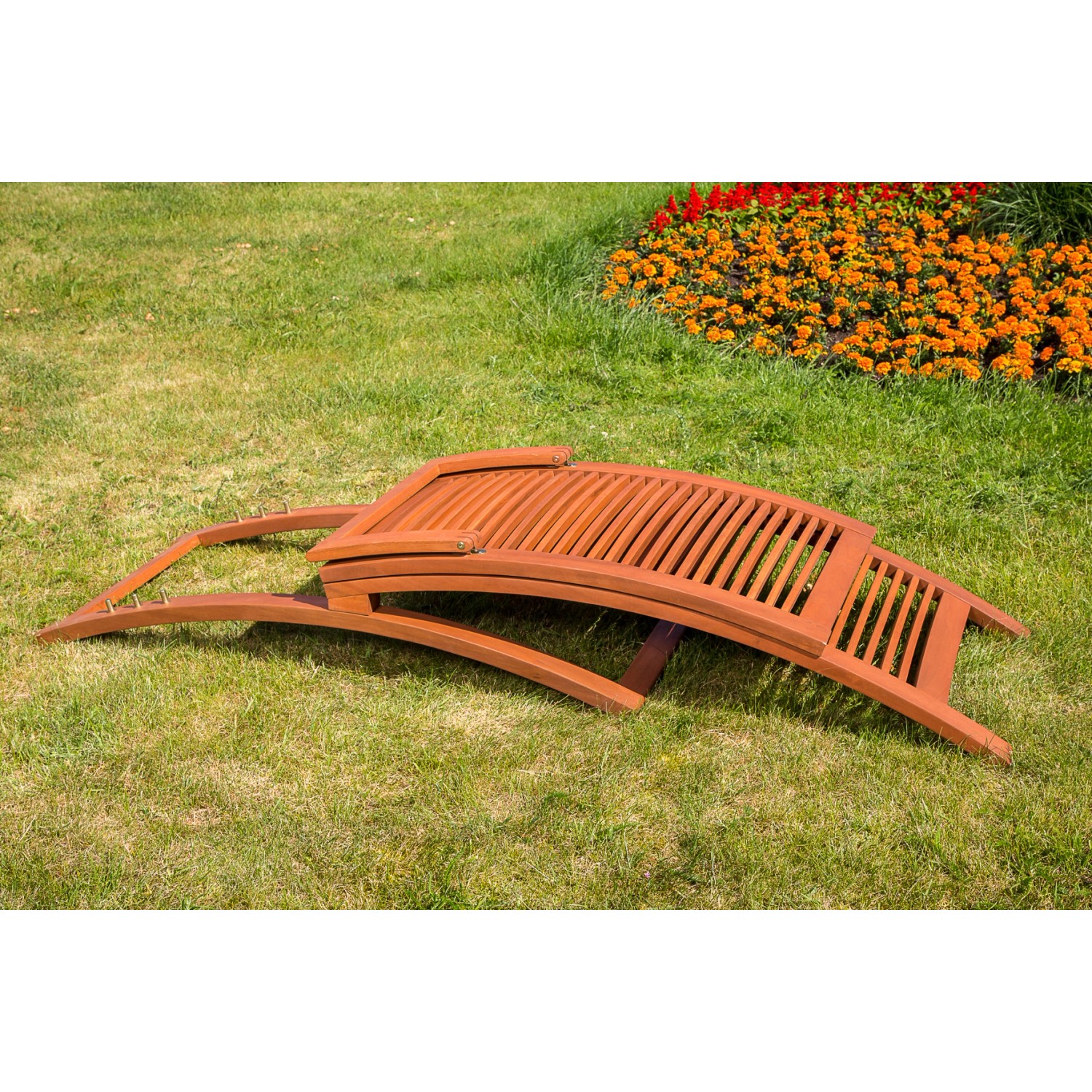 Zusammengeklappte Gartenliege Cuba aus Eukalyptusholz mit Lattenrost auf Rasen.