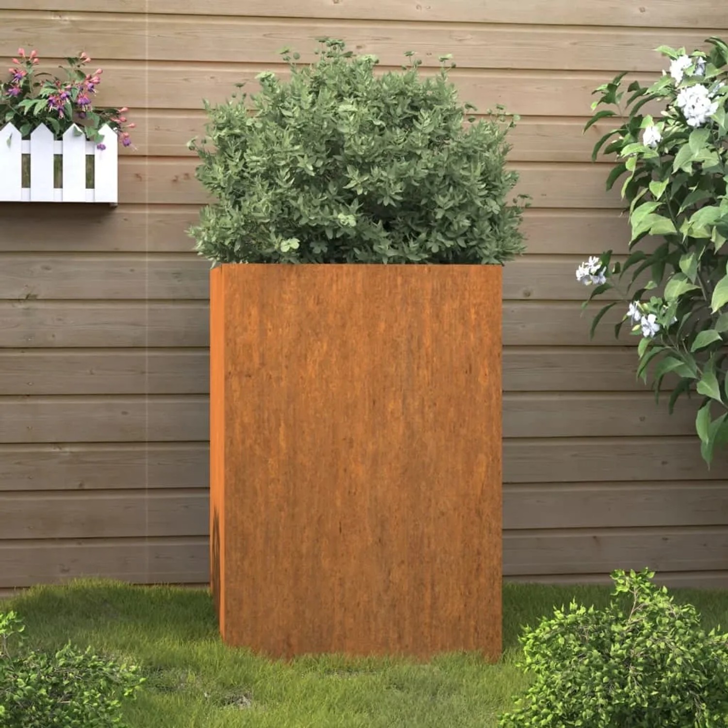 Hoher, rechteckiger Pflanzkübel aus rostigem Cortenstahl mit grüner Pflanze. Ideal für Garten, Balkon & Terrasse.