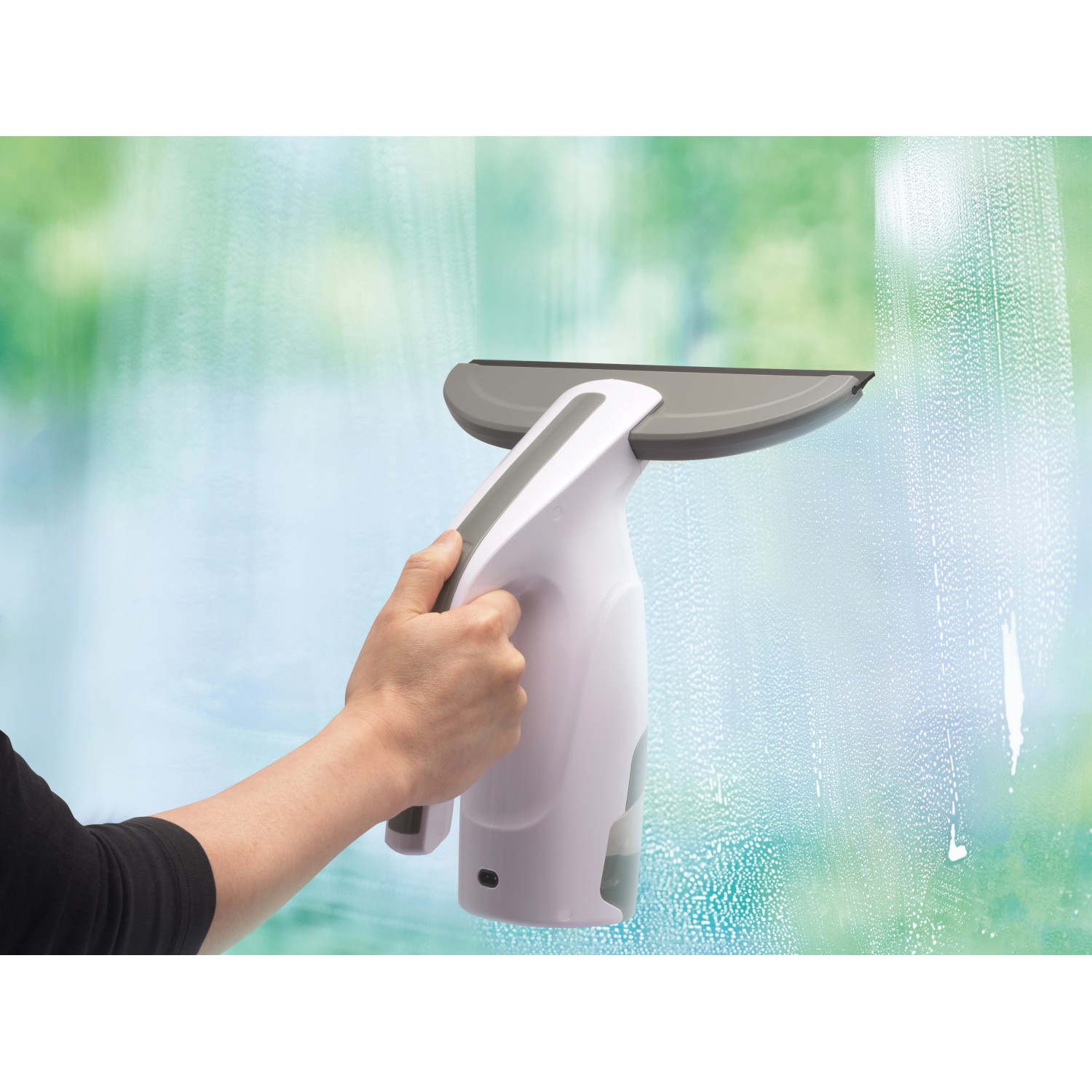 Akku-Fenstersauger mit Sprühflasche im Einsatz für streifenfreie Fensterreinigung.