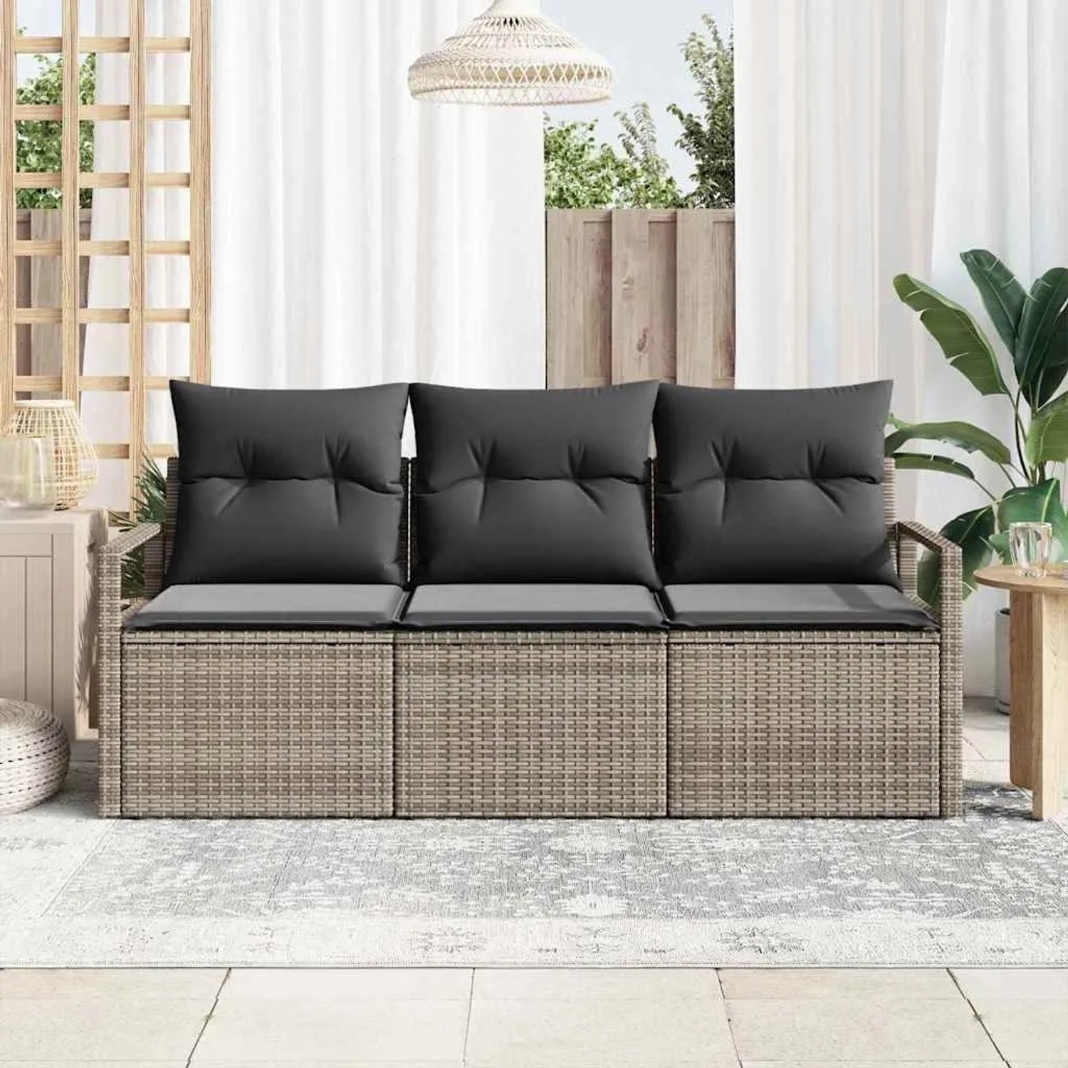 Modernes graues 3-teiliges Gartensofa-Set aus Poly-Rattan mit dunklen Kissen auf einer Terrasse.