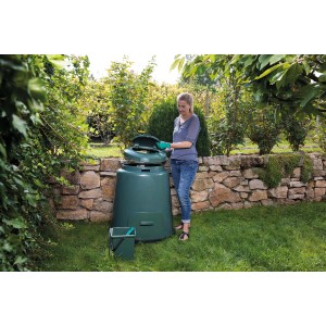 Grüner Garantia Schnellkomposter 280 l mit Frau im Garten beim Befüllen.