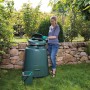 Grüner Garantia Schnellkomposter 280 l mit Frau im Garten beim Befüllen.