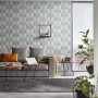 Wohnraum mit grauer Erismann Vliestapete Guido Maria Kretschmer Fashion for Walls mit Grafikmuster.