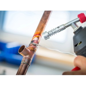 Löten von Kupferrohren mit LUX Fittingslot und einem Brenner. Sanitärinstallation.