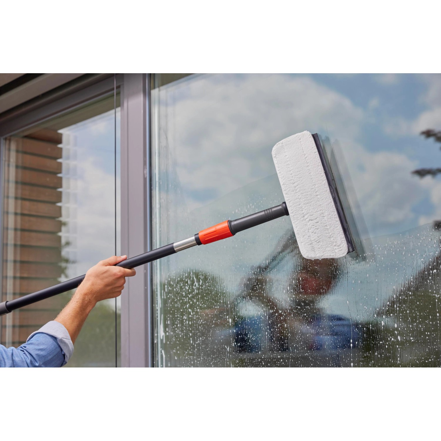 Gardena Cleansystem Fensterwischer mit Stiel und Mikrovlies im Einsatz zur Fensterreinigung.
