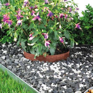 Bellissa Rasenkante Kreis Corten, Ø 20cm, als Beeteinfassung mit Pflanzen und Steinen.