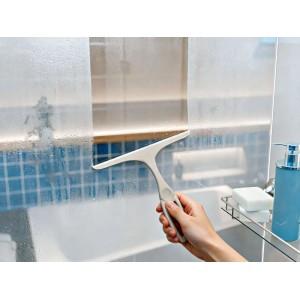 Hand zieht mit OBI Duschkabinenabzieher Wasser von beschlagener Glaswand ab. Für streifenfreie Dusche & Kalkschutz.