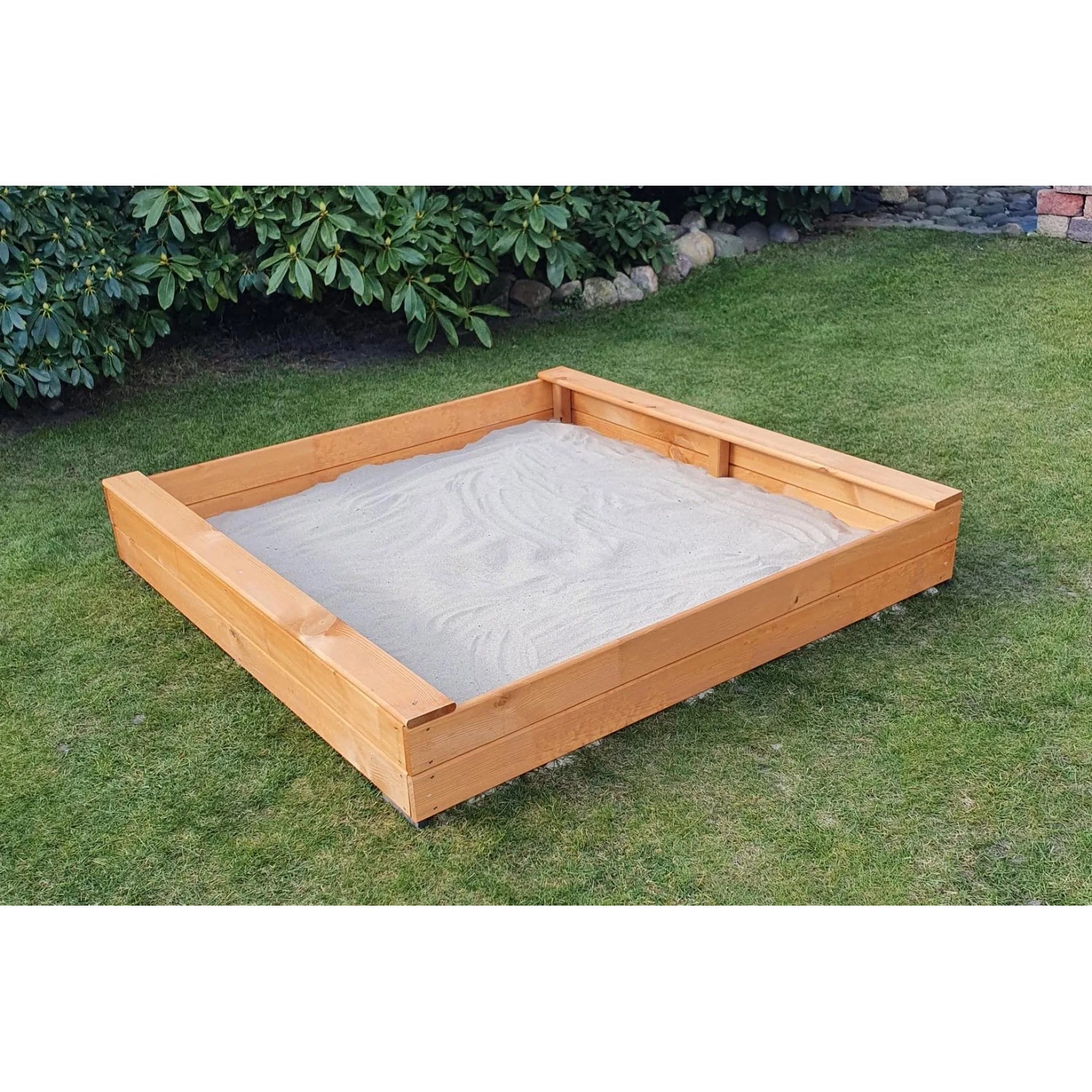 Quadratischer Promadino Sandkasten aus Kiefernholz, gefüllt mit Sand, im Garten.