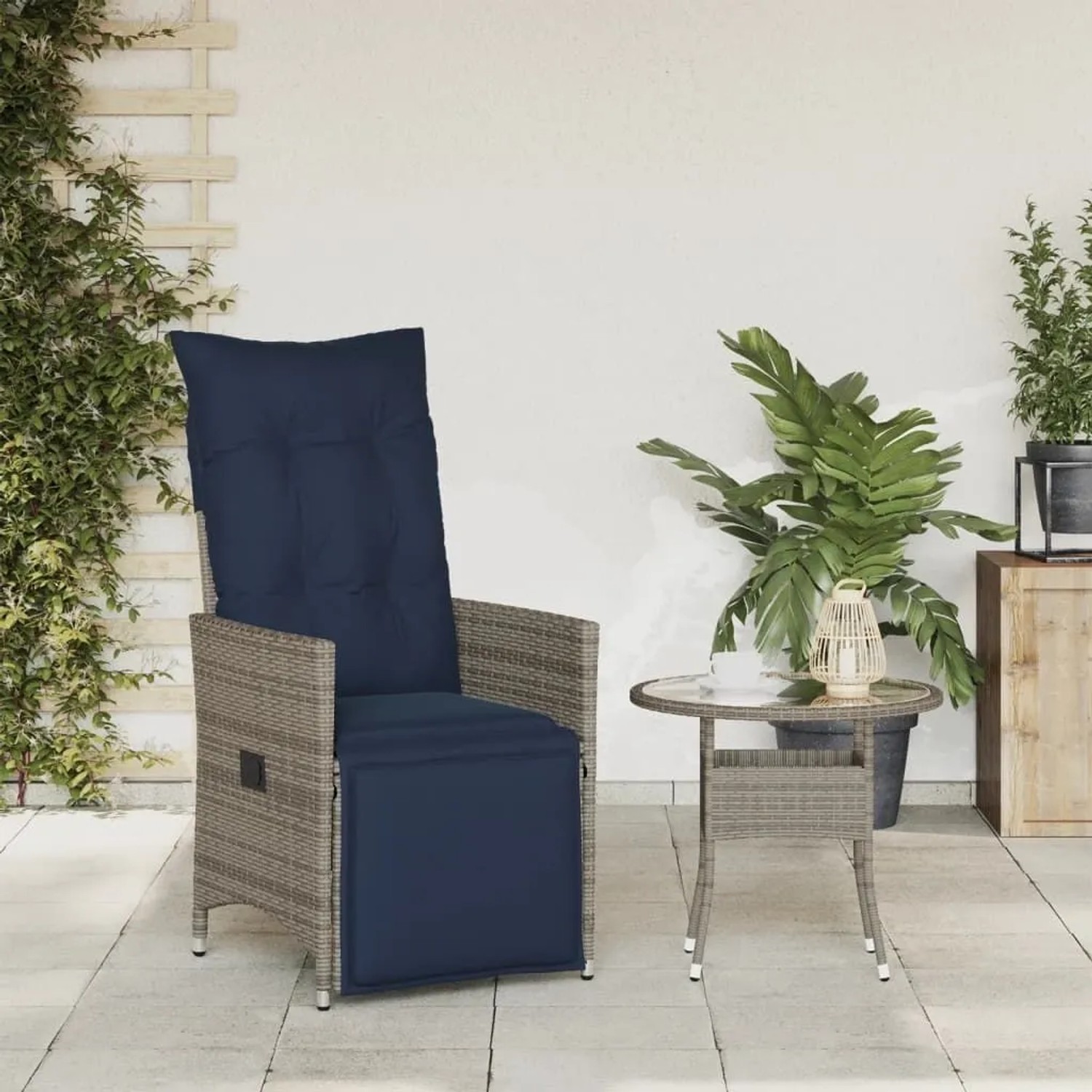 Verstellbarer vidaXL Gartensessel aus grauem Poly Rattan mit marineblauen Kissen auf Terrasse.