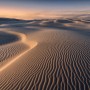Vlies Fototapete Glowing Lines: Wüstenlandschaft mit Sanddünen bei Sonnenuntergang.