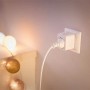 Weißer Philips Smart Matter Smart Plug Typ F in Wandsteckdose, misst Energieverbrauch. Ideal für smarte Leuchten.