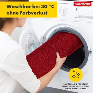 Rote Floordirekt Badematte Nasa wird in eine Waschmaschine gelegt.