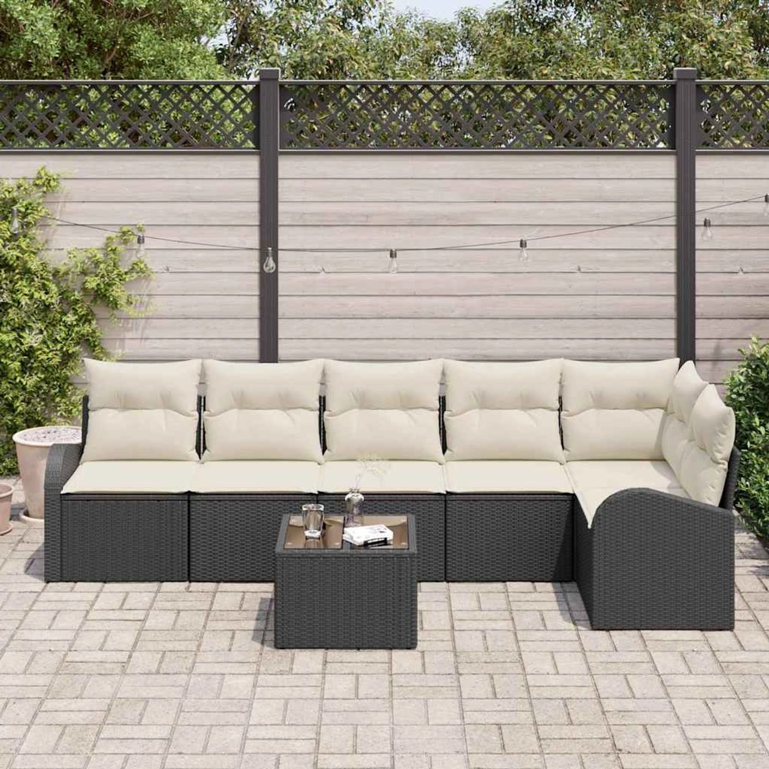 Schwarzes 7-teiliges Garten-Sofa-Set aus Poly Rattan mit Kissen und Tisch.