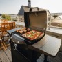 Enders Elektrogrill eUrban Pro 2 Turbo mit Trolley auf Balkon mit Grillgut und Pizza.