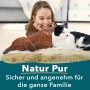 Mädchen, Dackel und Katze entspannen auf einem KARAT Schaffell Audrey Umber. Premium Lammfell für ein gemütliches Zuhause.