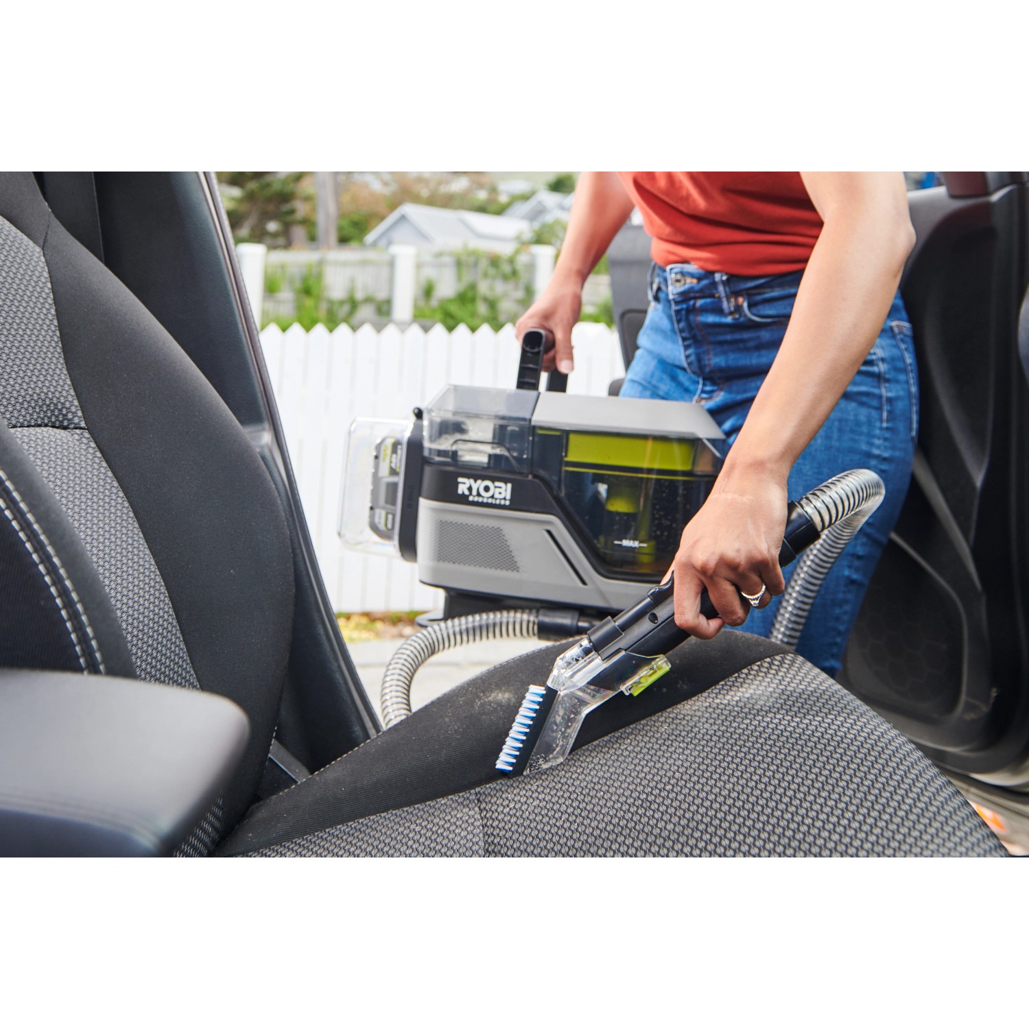 Ryobi Akku-Textilreiniger RDC18BL: Handstaubsauger im Einsatz zur Reinigung eines Autositze.