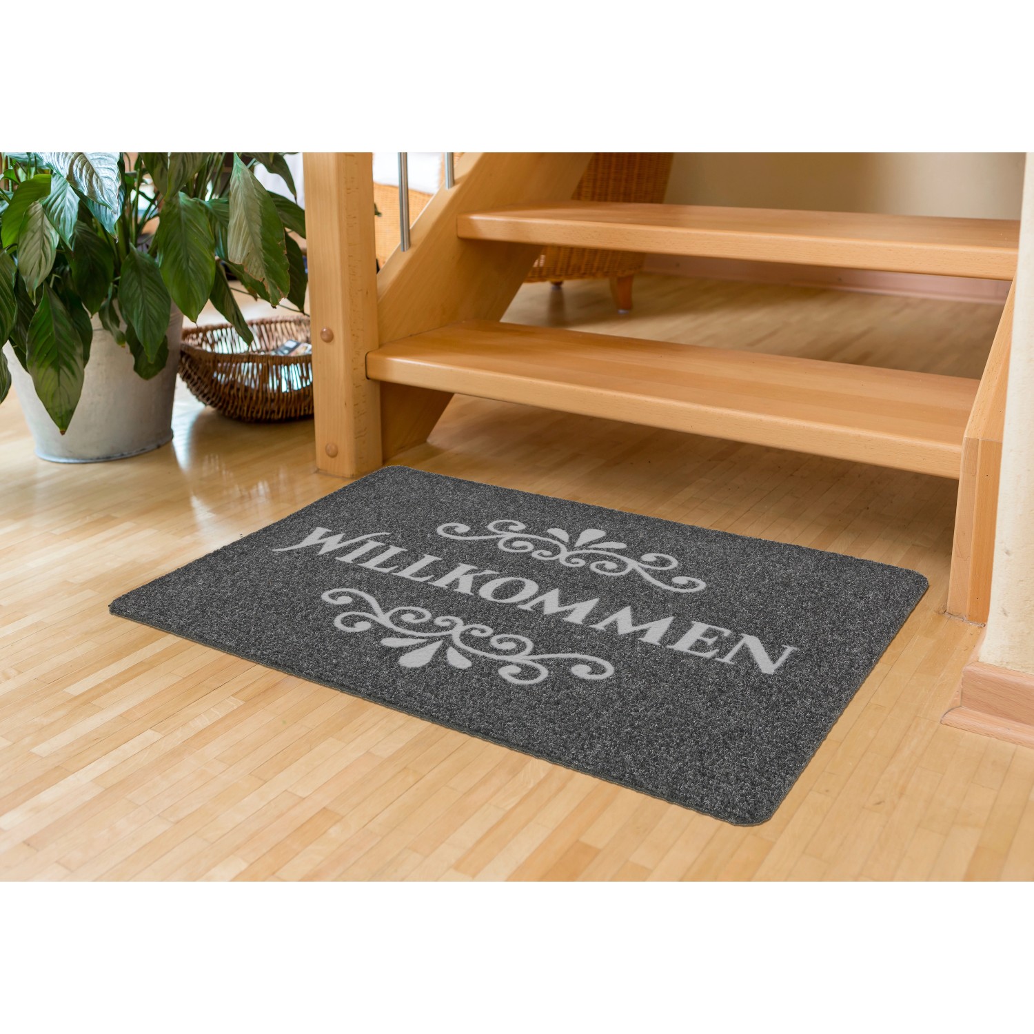 Graue ASTRA Fußmatte „Willkommen“ 50x80 cm vor einer Treppe. Schmutzfangmatte für den Innenbereich.