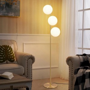 Goldene Stehlampe mit drei leuchtenden, kugelförmigen Milchglas-Schirmen im Wohnzimmer. Modernes Design für Innenleuchten.